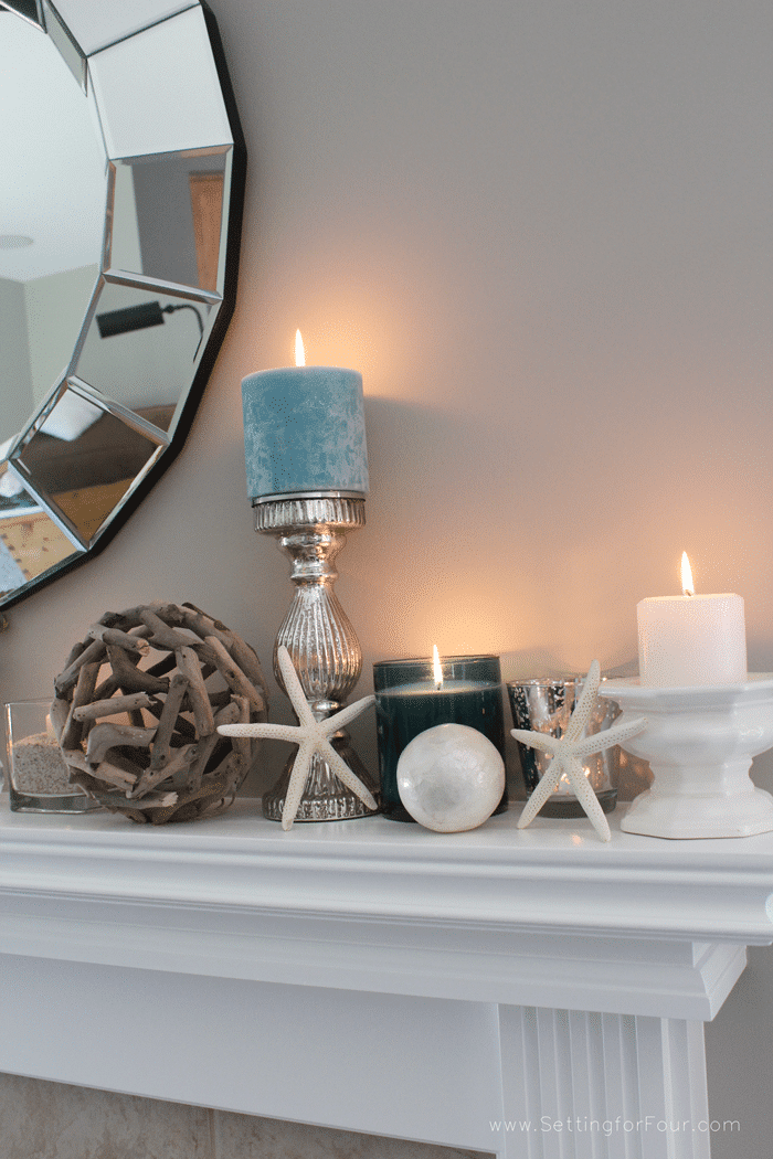 Home decorating ideas and tips: Learn how to decorate a Summer Beach Inspired Mantel with coastal colors and beach style accessories! Add pretty summer decor to your living room mantel with aqua blue candles, starfish, driftwood and capiz shell accents and a statement mirror.