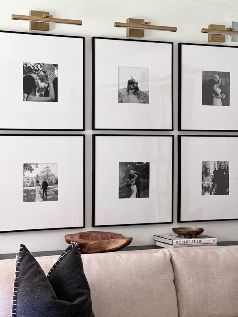 Gallery Wall Art Layout Above Sofa Idea, symmetrical grid style arrangement of black and white family photos, wedding photo display, picture lights above art, minimalist, modern, interior design ideas