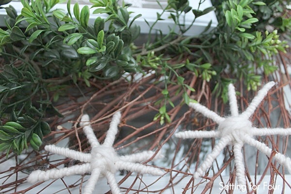 DIY Yarn Snowflake added to a Winter Boxwood Wreath