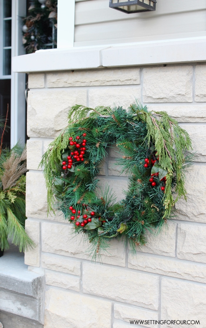 See my Christmas Entryway Decor with Winter Woodland Glam style! Front door wreath and garland decor, urns filled with greenery and birch. www.settingforfour.com