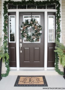 See my Christmas Entryway Decor with Winter Woodland Glam style! Front door wreath and garland decor, urns filled with greenery and birch. www.settingforfour.com