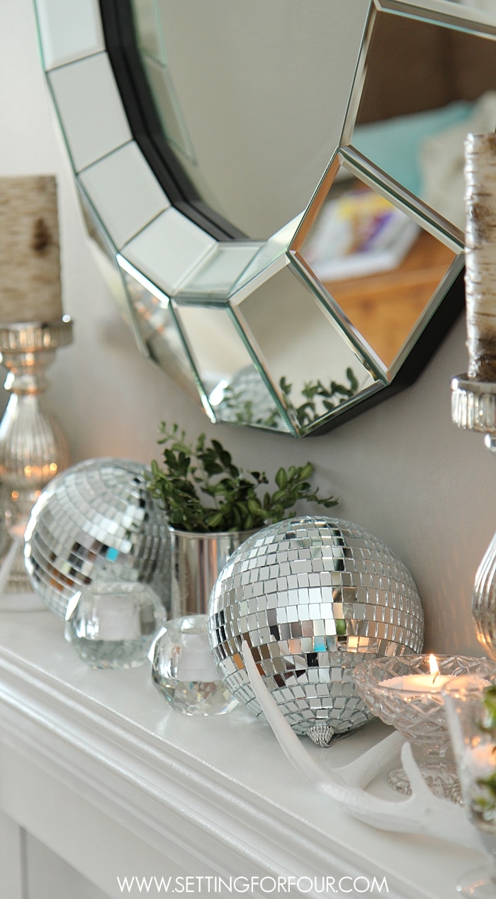 See these beautiful Winter Mantel Decorating Ideas - how to add sparkle and shine with fun disco balls and crystal votives mixed with rustic beauty of deer antlers and birch candles! See more of the decor ideas at www.settingforfour.com