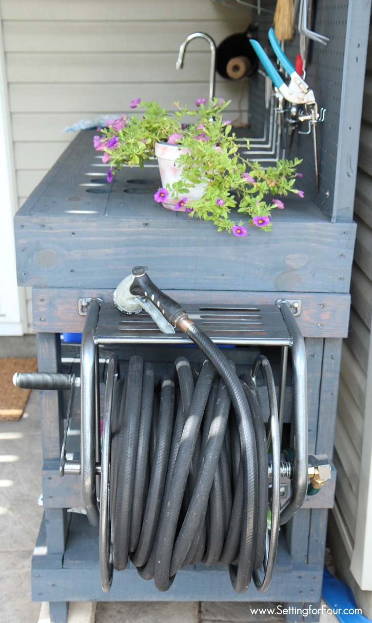 Love to garden? This DIY Pallet Wood Potting bench was so inexpensive to make and has all the bells and whistles! Like a Mounted Hose Reel with Gardening Hose connected to a water supply for watering my flowers and gardens! See instructions and supply list at www.settingforfour.com