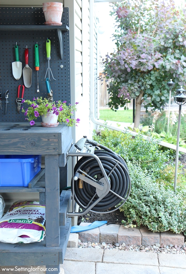 Love to garden? This DIY Pallet Wood Potting bench was so inexpensive to make and has all the bells and whistles! Like a Mounted Hose Reel with Gardening Hose connected to a water supply for watering my flowers and gardens! See instructions and supply list at www.settingforfour.com