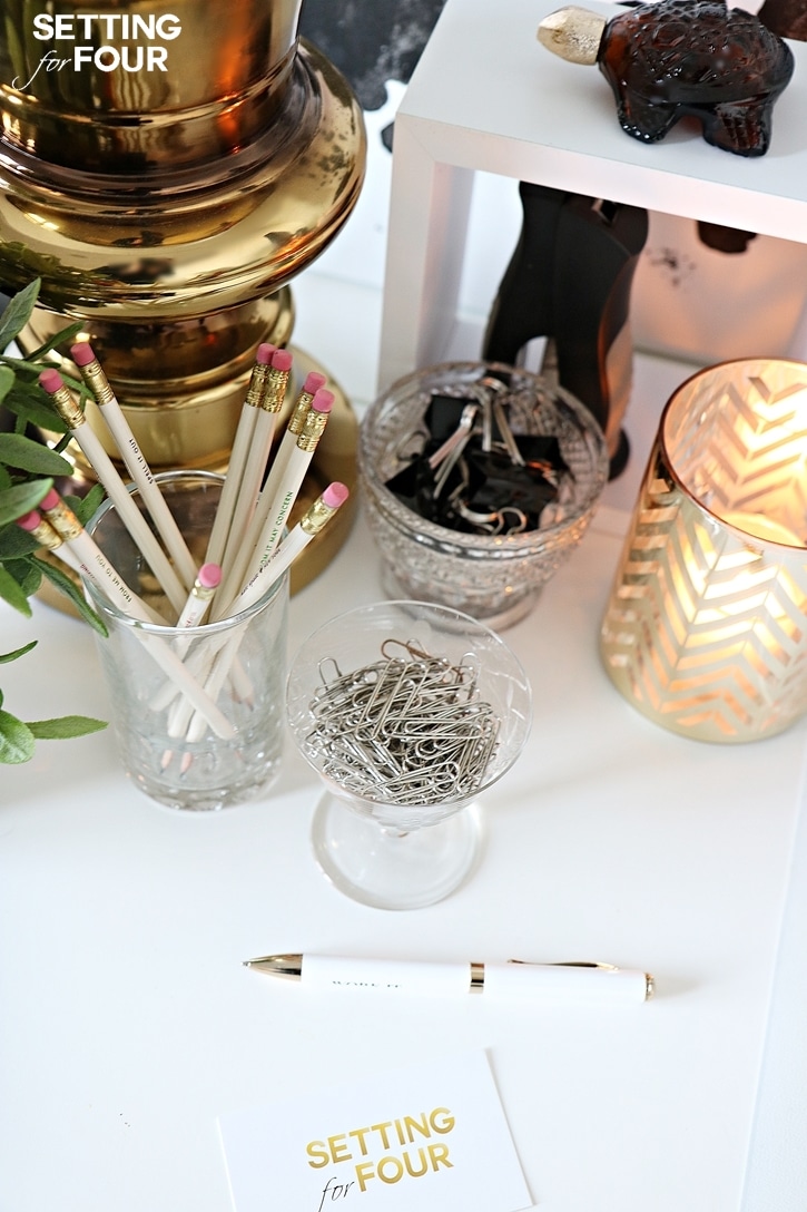 Use a clear water glass to organize and hold pencils and pens - so much prettier than those plastic pen holders! It's simple and it works! See all five of my 10 Minute decorating tips to organize your desk here at www.settingforfour.com