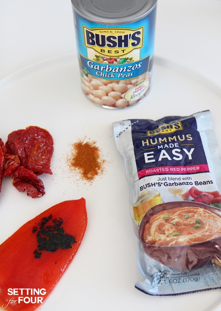 Roasted Red Pepper Hummus with Sun-Dried Tomatoes: Bored with your every day snack routine? Mix it up with the NEW BUSH'S® Hummus Made Easy in a pouch - a homemade, creamy hummus recipe that you can whip up in just three simple steps! Just 5 minutes to prepare. You'll love this easy vegetarian recipe - makes a quick and delicious party dip and spread. Get the recipe at Setting for Four.