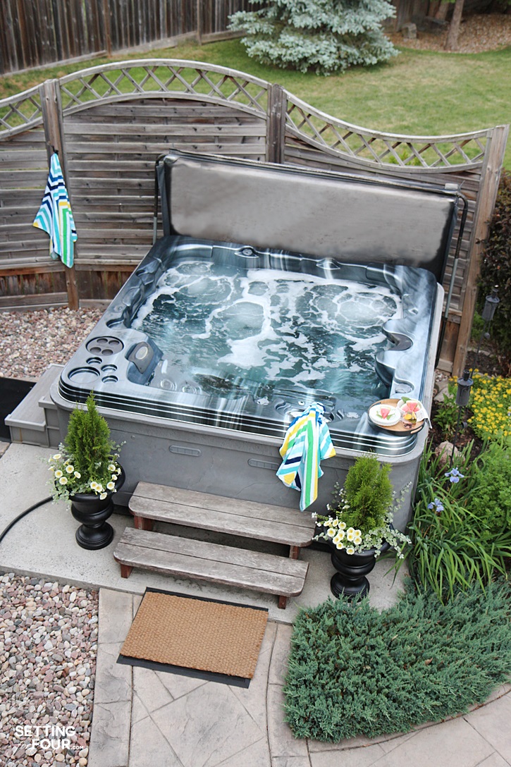 Hot tub in the summer with landscaping plants.