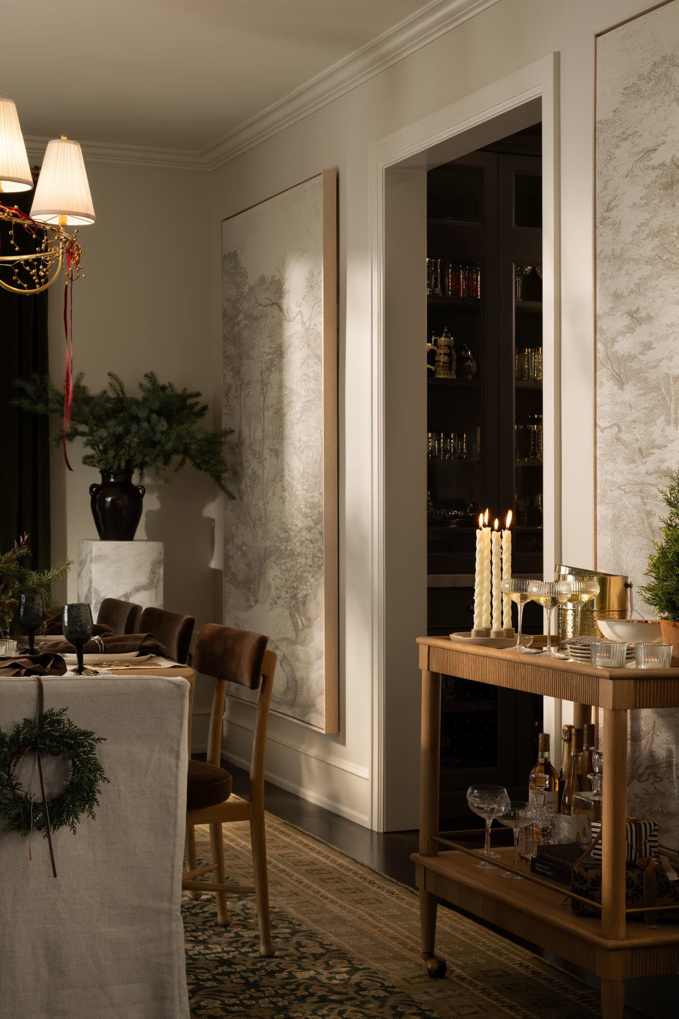 Neutral Christmas Dining Room Decor Ideas, cozy, elegant, holiday decorating inspiration with a Christmas bar cart, wreaths hung on dining chairs, festive decor, landscape wall art to fill blank walls, moody, earthy color scheme, creamy wall color idea, organic modern, transitional style, Studio McGee home aesthetic