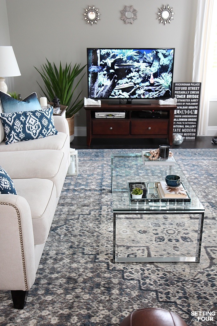 Add small decorative mirrors above a TV unit. Living room indigo blue color palette.