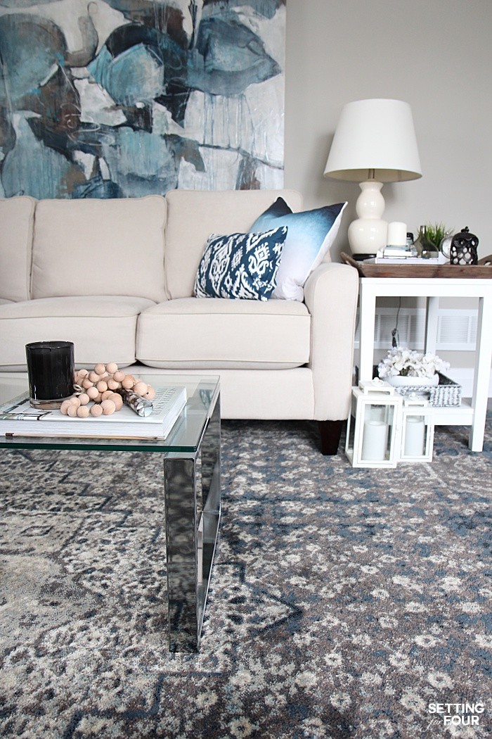 Indigo living room color palette. Pops of indigo blue art, pillows and rug add style to neutral colored walls and furniture. 