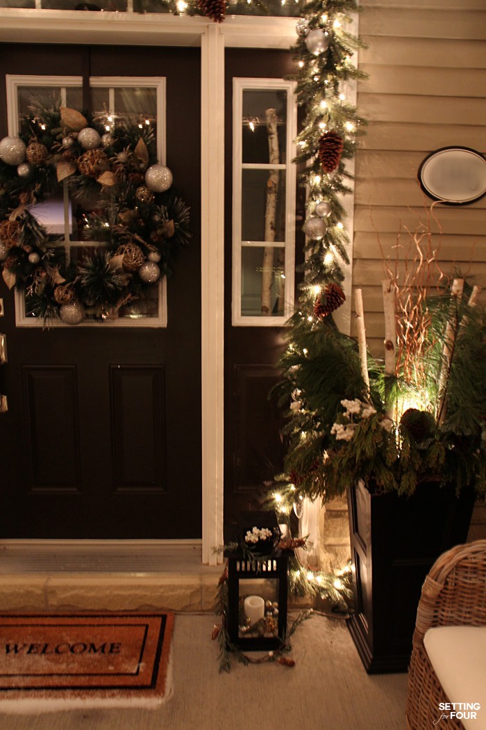 Magical Christmas Lights at Night Home Tour - our front porch with pine garland and Christmas urns lit at night.