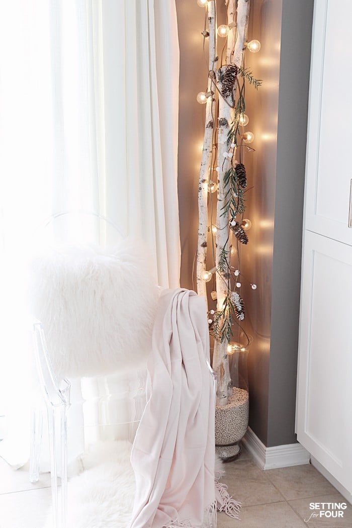 See this quick 10 Minute Winter Decorating Birch Branches Idea! Beautiful birch tree logs in a vase draped with gold globe lights will brighten gloomy winter days and is a great way to decorate a small space in your home! Perfect for a tiny house, apartments and condos!