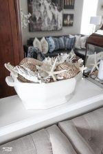 Learn how to make a Pretty Faux Coral & Starfish Coastal Summer Centerpiece that's quick and easy to put together! This Pottery Barn inspired centerpiece is the perfect table top, coffee table and bookshelf decor for parties, weddings or to update your home for summer. If you love coastal decor and collect shells you'll love this beautiful sea inspired arrangement!