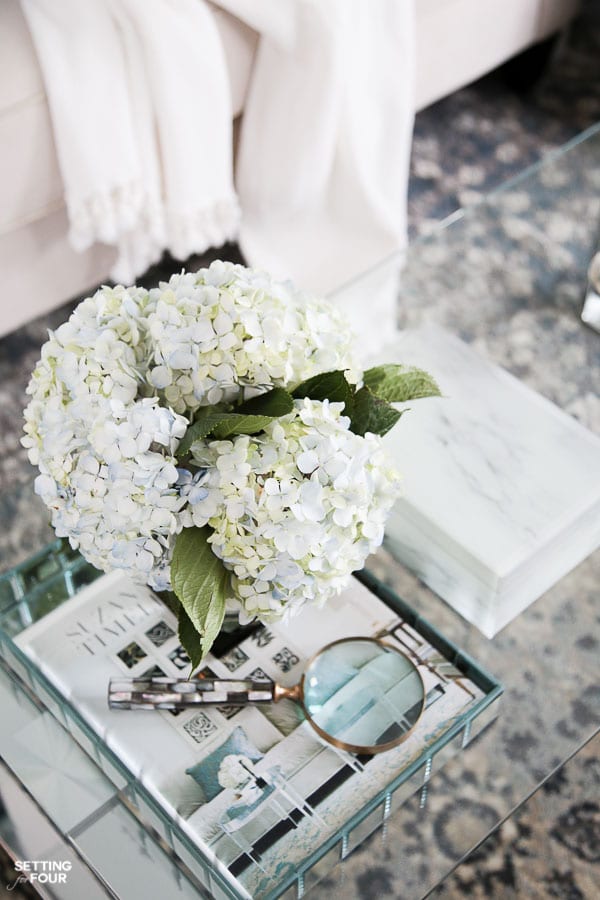 Coffee table styled with tray, hydrangea bouquet, coffee table books.