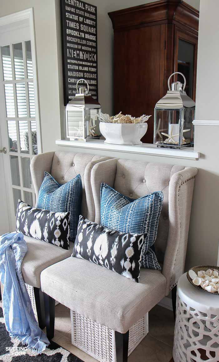 Need some new decorating ideas? See my foyer decor ideas including my indigo blue, black and gray color scheme, make this DIY coastal centerpiece, lanterns, garden stool, seating, area rug and pillow accents.