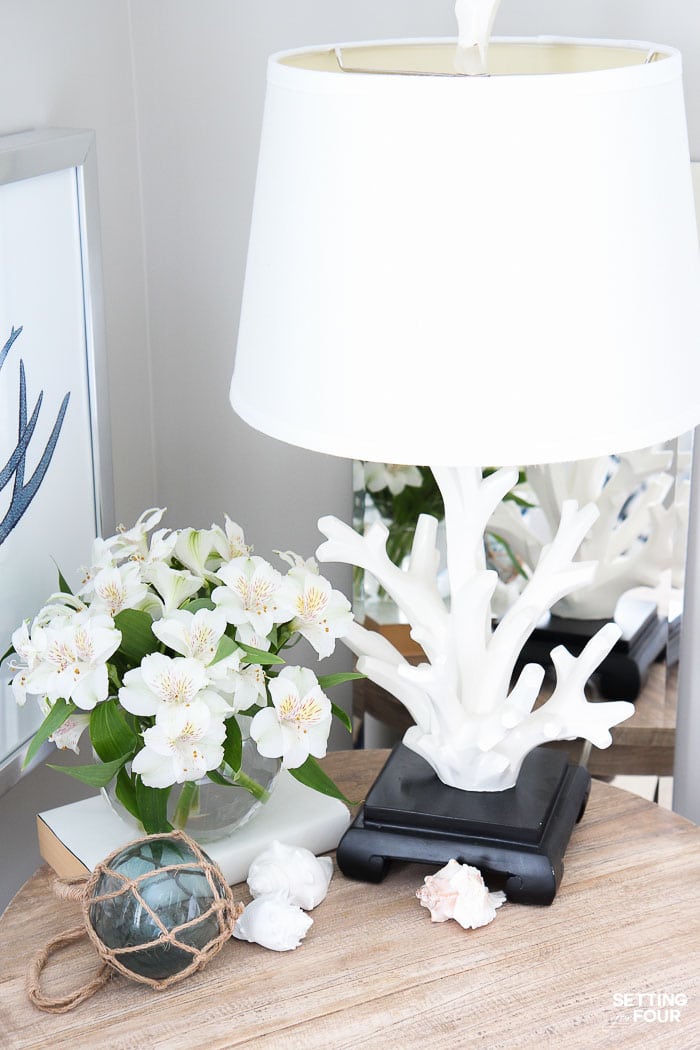 Simple Nightstand Decor Ideas. elegant decorating ideas, white, blue, minimalist, coastal, table lamp, side table, table lamp, lighting, vase of flowers, wall art, transitional, modern farmhouse, beach house, Airbnb, cottage, calm, relaxing, nightstand decorations.