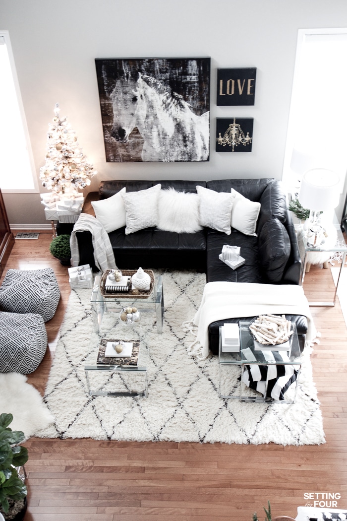 See my Glam Black, White and Gold Family Room Decor Ideas! I kept my holiday decor simple this year - a mini flocked Christmas tree with gold and silver ornaments, some faux pine greenery and bowls of metallic Christmas balls keep this space looking light and bright but festive too! See my entire family room here! Leather sectional sofa, poufs, shag area rug, crystal table lamps, chunky knit throw blanket, black and white color palette, faux fur pillows, metallic wall art.