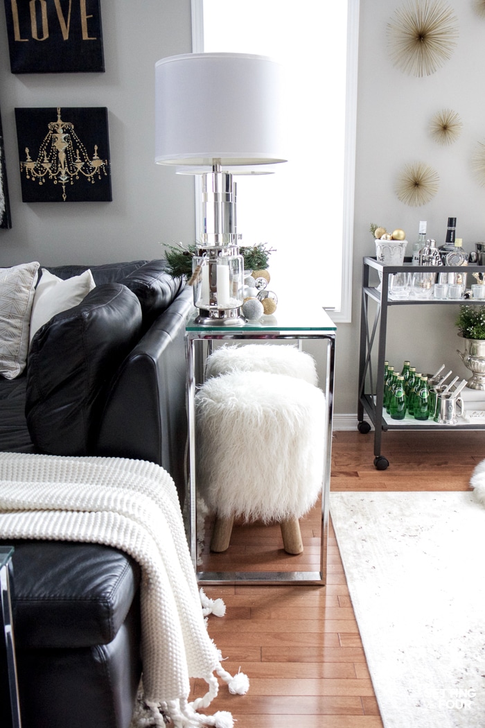 See my Glam Black, White and Gold Family Room Decor Ideas! I kept my holiday decor simple this year - a mini flocked Christmas tree with gold and silver ornaments, some faux pine greenery and bowls of metallic Christmas balls keep this space looking light and bright but festive too! See my entire family room here! Leather sectional sofa, poufs, shag area rug, crystal table lamps, chunky knit throw blanket, black and white color palette, faux fur pillows, metallic wall art.