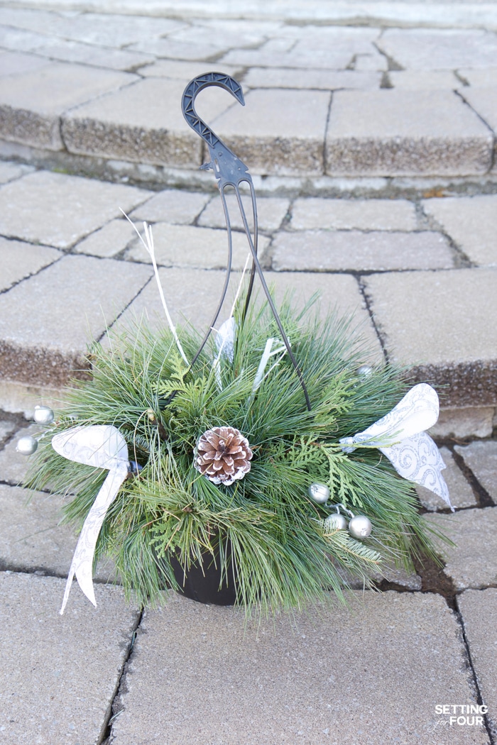 How to turn a basic Christmas hanging basket into a stunning outdoor Christmas urn planter for your front door! Add curb appeal to your home in a jiffy!