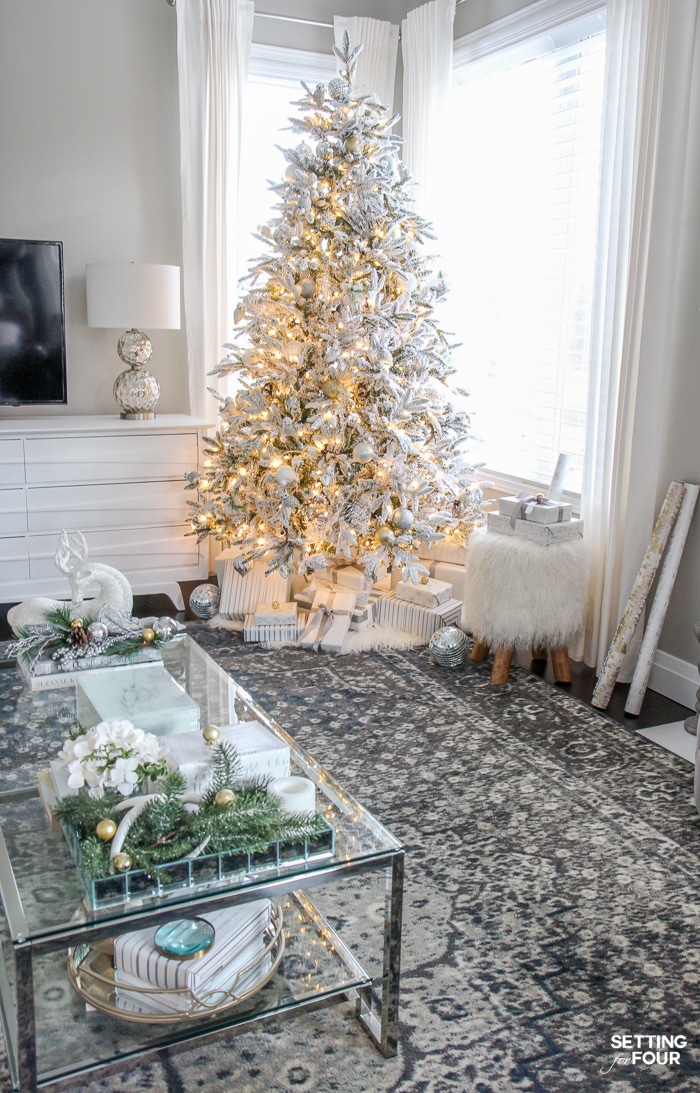 White Flocked Christmas Tree in a transitional style home. See the decorating tips to get this look! See the sources for the coffee table, area rug, lamp, flocked tree, Mongolian fur stool and the gray wall paint color in the blog post.