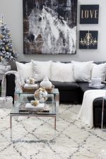 See my Glam Black, White and Gold Christmas Family Room Decor Ideas! I kept my holiday decor simple this year - a mini flocked Christmas tree with gold and silver ornaments, some faux pine greenery and bowls of metallic Christmas balls keep this space looking light and bright but festive too! See my entire family room here including our leather sectional sofa, poufs, shag area rug, crystal table lamps, chunky knit throw blanket, black and white color palette, faux fur pillows, metallic wall art.