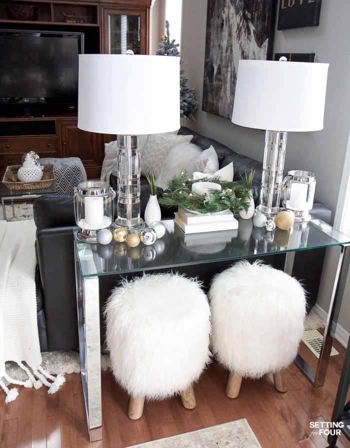 See my Glam Black, White and Gold Family Room Decor Ideas! I kept my holiday decor simple this year - a mini flocked Christmas tree with gold and silver ornaments, some faux pine greenery and bowls of metallic Christmas balls keep this space looking light and bright but festive too! See my entire family room here! Leather sectional sofa, poufs, shag area rug, crystal table lamps, chunky knit throw blanket, black and white color palette, faux fur pillows, metallic wall art.