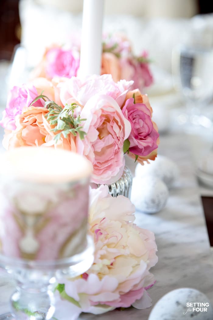 Easter tablescape: pink floral centerpieces and pink marbled candles with a marble runner.