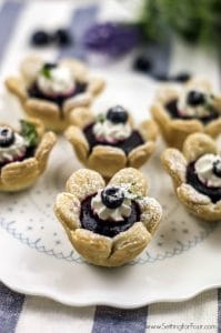 These delicious blueberry flower tarts are fun to make and serve! Satisfy your sweet tooth with this mini fruit filled dessert with a flower shaped crust- perfect for brunch, baby showers, wedding showers and dinner parties!