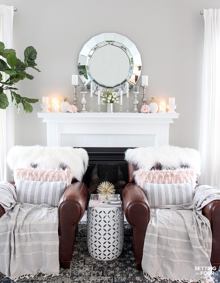 Bright living room with fireplace, leather armchairs, mirror above mantel and fireplace mantel decor.