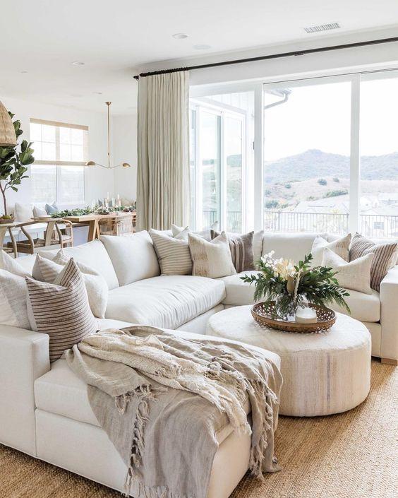 Modern Organic Living Room Decorating Ideas with furniture selection and arrangement tips, U shaped sectional sofa and round coffee table in neutral colors, natural decor ideas, bright, cozy living room design ideas.