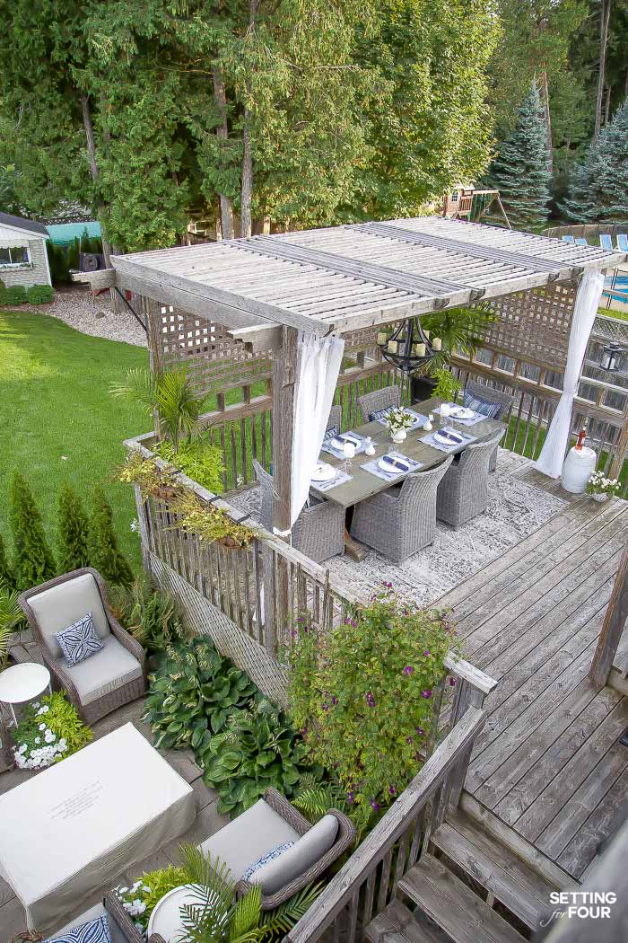 Backyard Patio and Pergola Dining Area Design and Decor Ideas. Patio furniture, fire table, patio chairs, outdoor area rug, planters, landscaping ideas.