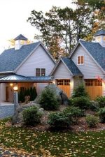 Beautiful fall home exterior with stone exterior and driveway curb appeal