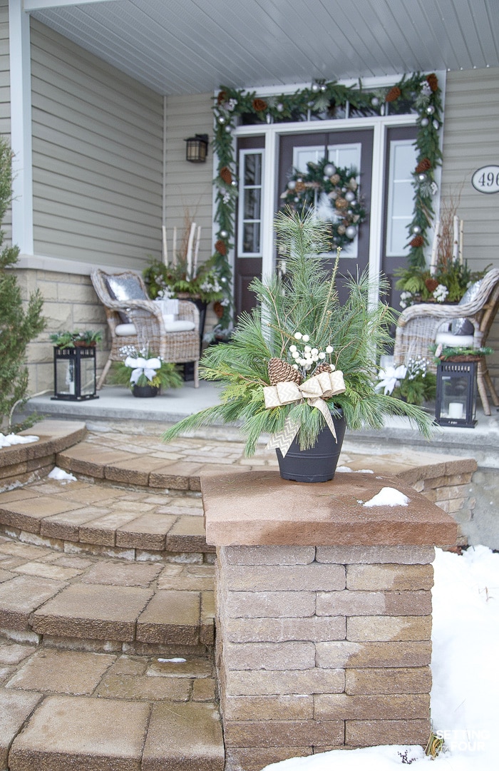 Add festive layers of greenery, soft metallics and shimmer to create a welcoming Christmas porch!