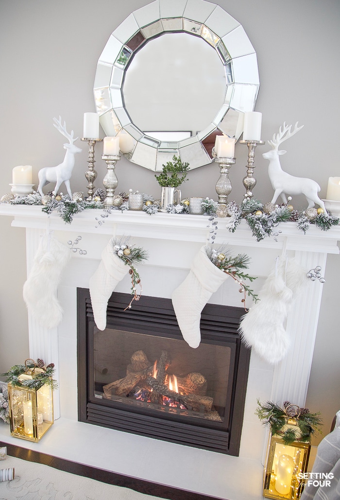 Simple white fireplace mantel with mirror decorated for Christmas with lanterns and twinkle lights #christmasmantel #twinklelights #christmaslights #mirror #fireplace #lanterns