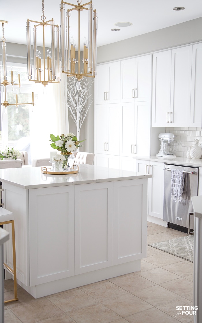 White kitchen island with quartz countertop and two pendant lights over the island. #kitchen #island #pendant #lighting #countertop 