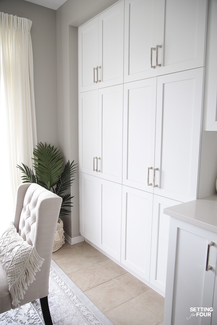 Floor to ceiling white builtin pantry cabinet doors in a white kitchen.