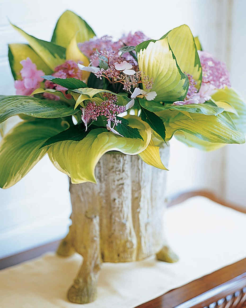 Hosta and hydrangea flower arrangement in a vase.
