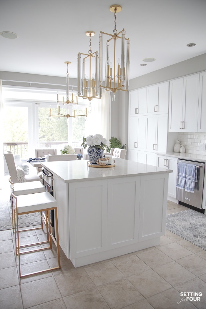 White kitchen cabinets and brass and crystal pendant lights