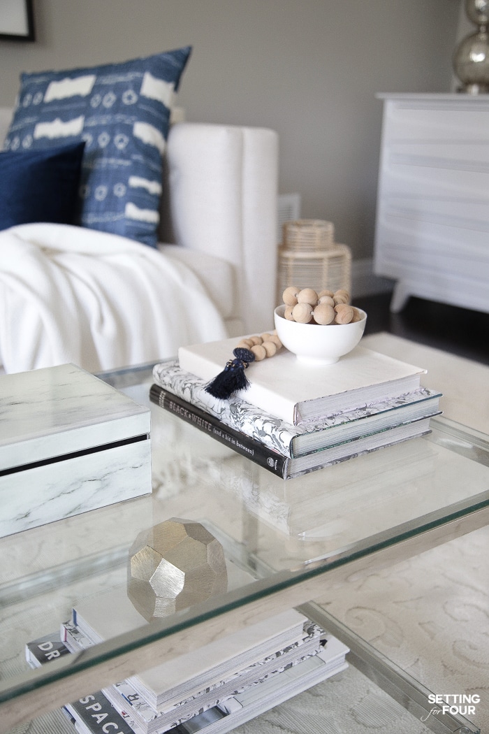 Coffee table decorated for summer with wood bead garland and coffee table books.