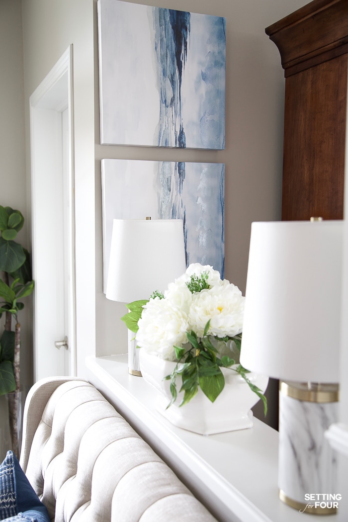 Entryway wall with abstract blue and white art hung on the wall.