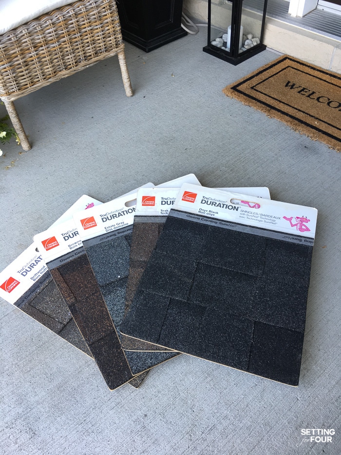 5 large shingle samples from a supplier laid on the front step of a home to choose the perfect roof color.