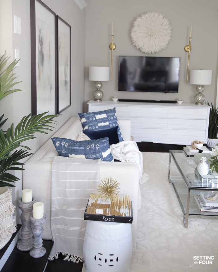 Living room sofa with wall art hung above sofa and console media unit.