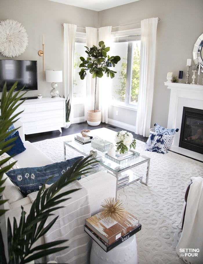 Living room with fireplace, rectangular coffee table and sofa and media unit.