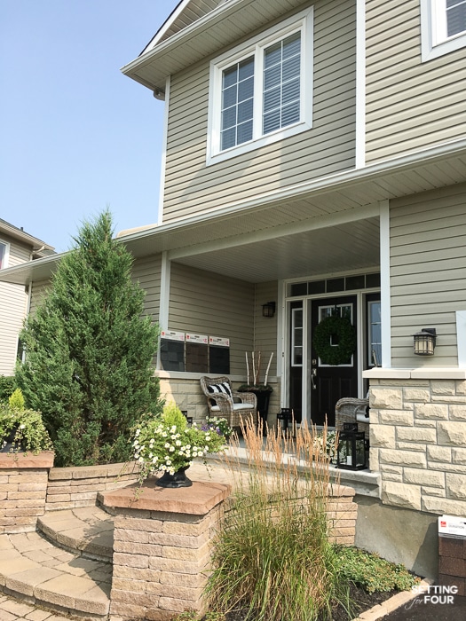 Shingle samples propped up by the vinyl siding of a home.