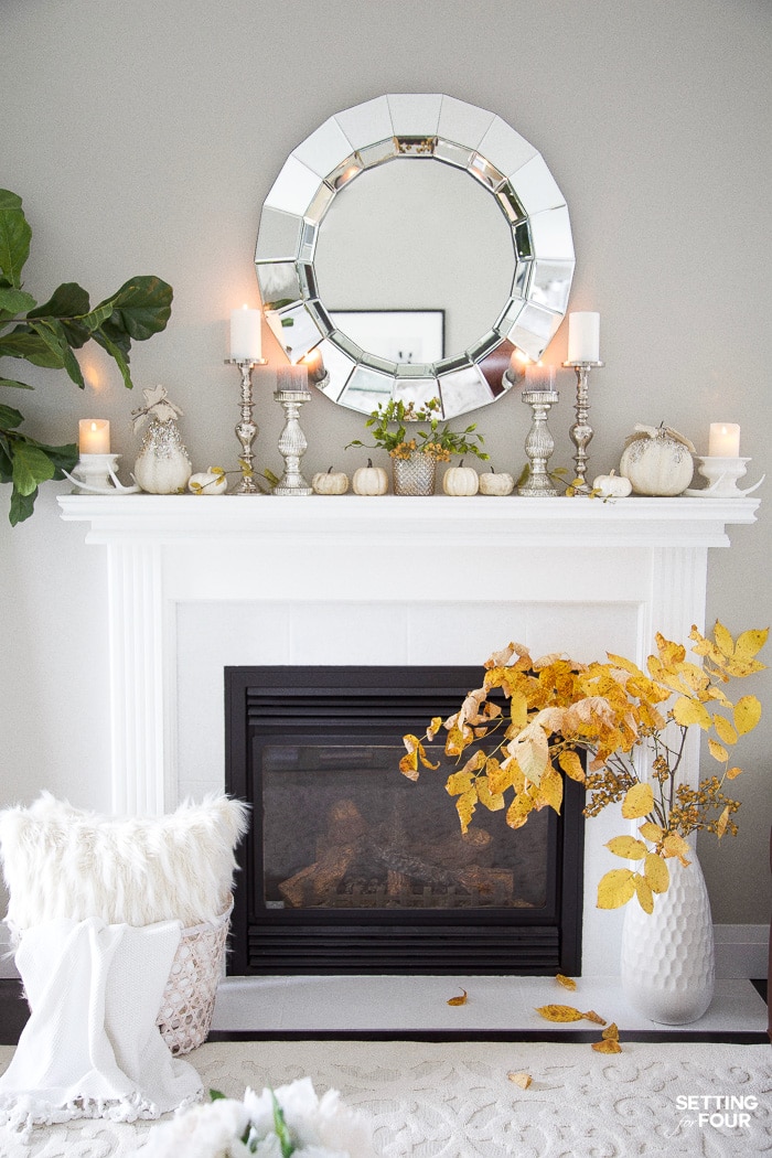 Round faceted mirror above a fireplace mantel in a living room.