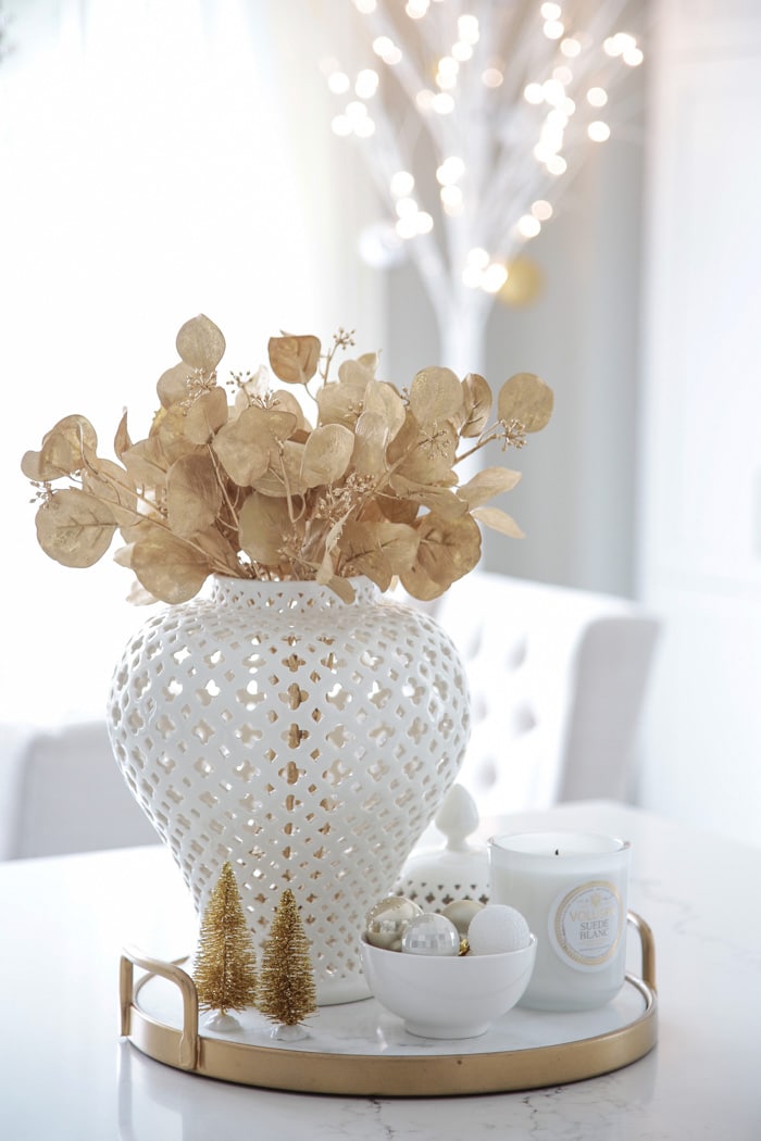 Christmas centerpiece decor idea with white ginger jar and gold eucalyptus spray for kitchen island.