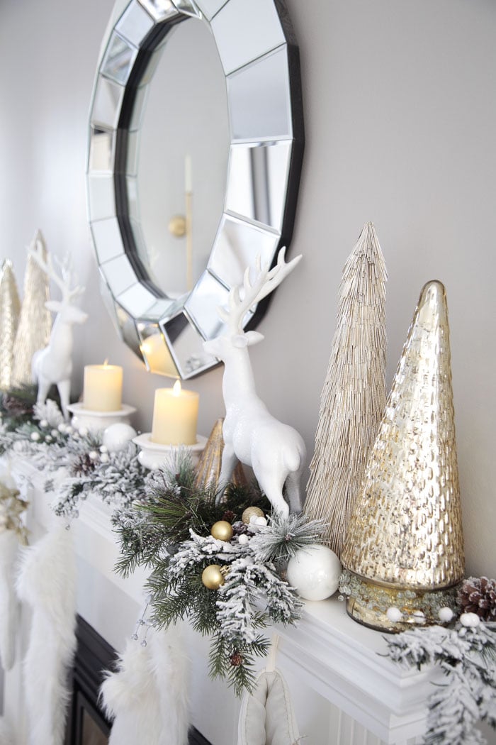 Gold and White Living Room Fireplace Mantel Decor Ideas with reindeer, pine garland and glass Christmas trees.