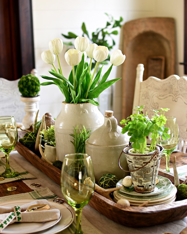 Rustic farmhouse St. Patrick's Day tablescape idea with moss balls and shamrock plant centerpiece.