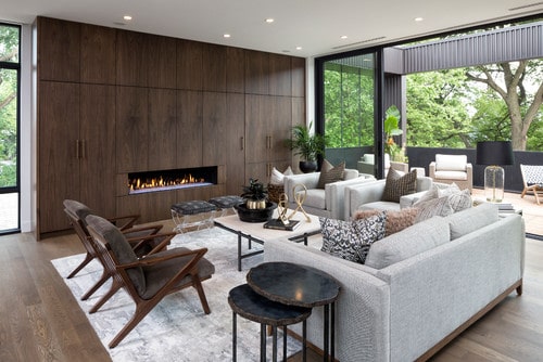 Sofa and four chairs arranged in an open concept living room with fireplace.