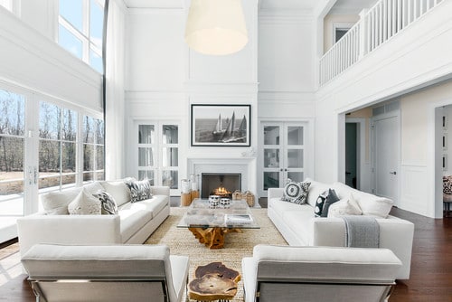 Two sofas and two chairs arranged in an open concept living room with fireplace.